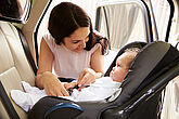 Child safely secured in a child car seat in the back seat of a car.