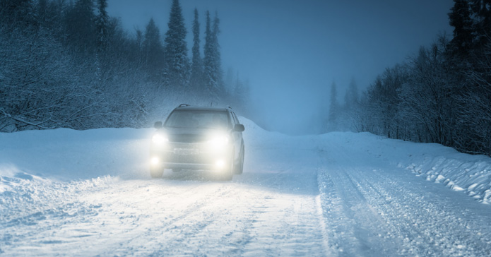 Auto fährt über Schnee bei Dunkelheit 