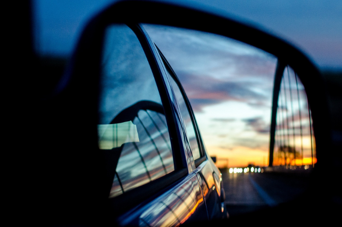 Blick in einen Außenspiegel mit Verkehr im Hintergrund